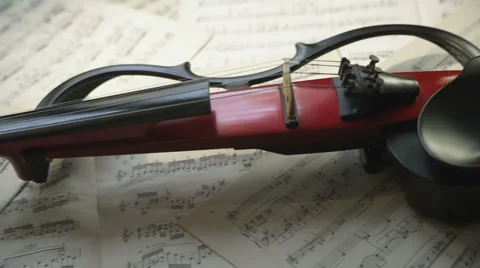 Electric violin lying on musical notes background Stock Footage 65416785