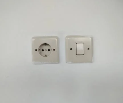 Electric Wall Socket and Light Switch Side by Side on White Wall Stock Photos