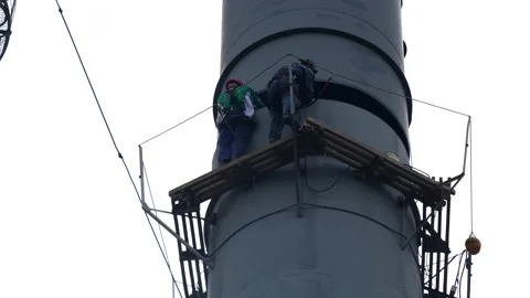 An electric welder prepares the base for installing a chimney Stock Footage 249527014