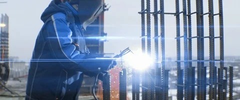 Electric welding on top of multi-storey building. Caucasian worker in mask Stock Footage 119496696