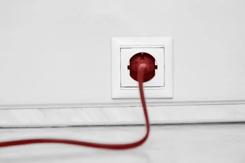 Electric white socket and one plugged in power cord on white wall background Stock Photos