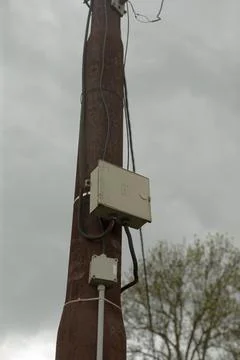 Electrical access point on pole amidst rural environment and stormy weather Stock Photos