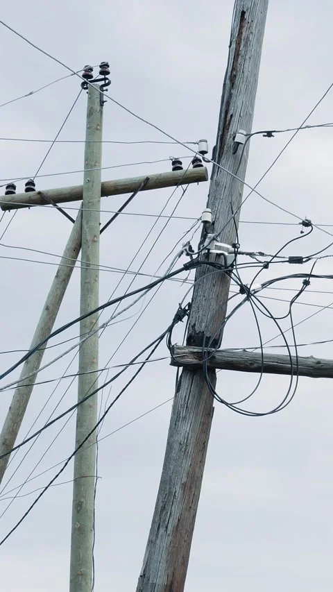 Electrical and telecommunication cables are suspended from a wooden pole. Stock Footage 282086119
