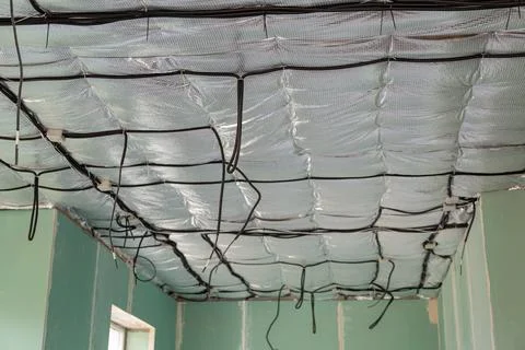 Electrical cable installation above insulated ceiling during house constructi Stock Photos