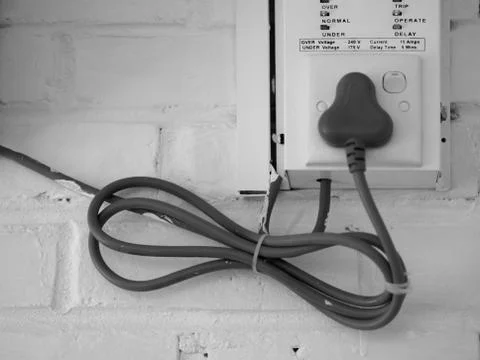 ELECTRICAL CABLE ON WHITE BRICK WALL Stock Photos