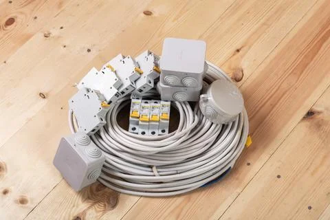 Electrical cables and circuit breakers arranged on wooden surface for Stock Photos