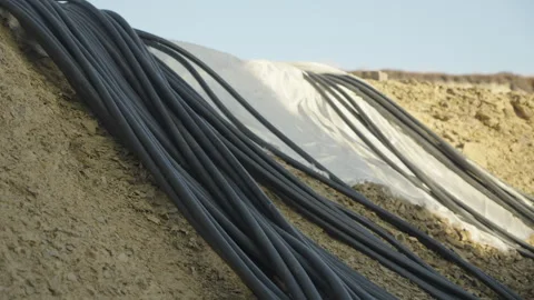 The electrical cables are routed out of the wind turbine's concrete foundation 스톡 동영상 347411232