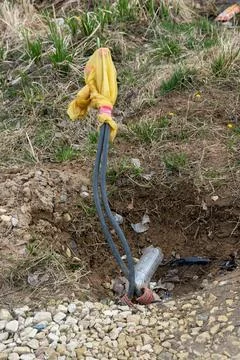 Electrical cables emerging from the ground covered with plastic bag Foto stock