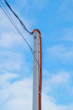 Electrical cables running up an electricity pole against a blue sky, concept of Stock Photos