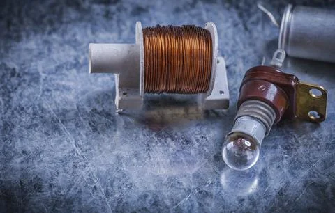 Electrical capacitor switch transformer lamp socket on scratched metallic Stock Photos