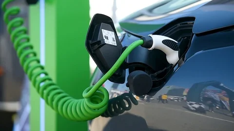 Electrical car plugged through a charging cable to a charging station. 스톡 동영상 119074307