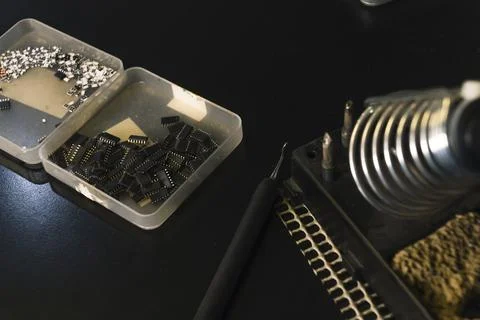 Electrical components of circuit board stored in plastic cases on black table Stock Photos