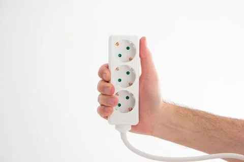 Electrical cord with multiple plug sockets held in hand by Caucasian male han Foto stock