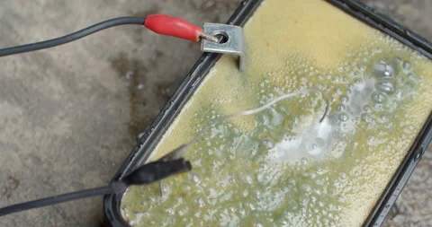 Electrical current reacting with rusted metal in water during the electrolysis. Stock Footage 312949497