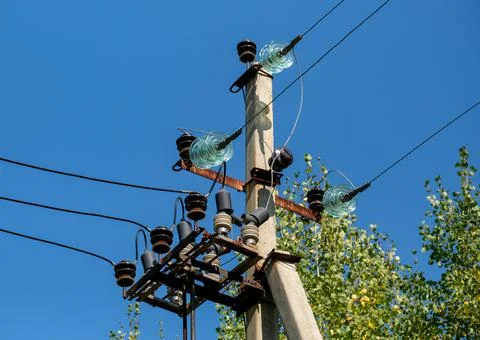 Electrical device on the pole. Wires and glass mounts and arresters. Blue sky Stock Photos