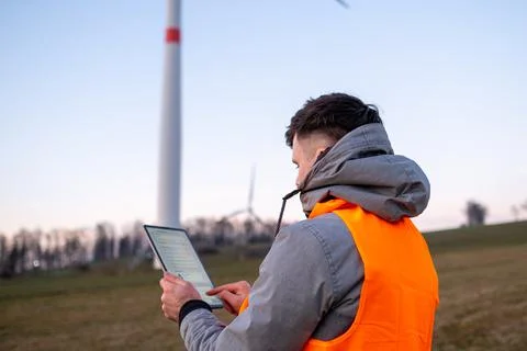 Electrical engineer checking or repairing wind turbines in the field using a 写真素材