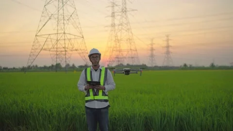 Electrical engineer control a drone To inspect high voltage poles Stock Footage 148356540