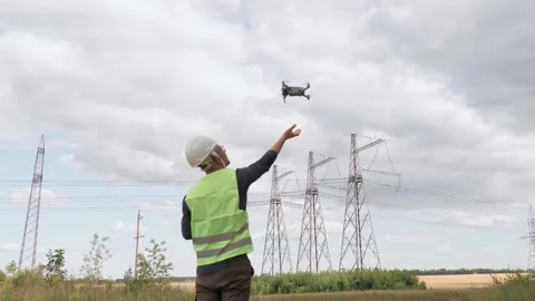An electrical engineer forcing a drone To inspect high voltage poles before Stock Footage 167058188