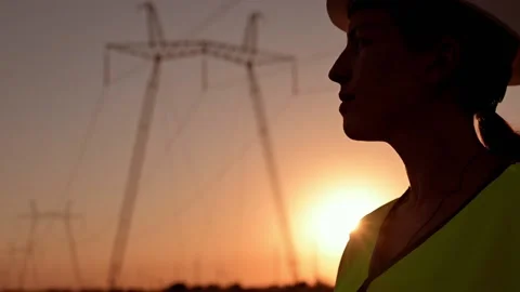 Electrical engineer in hardhat talking on the phone at sunset near the Stockbeeldmateriaal 201032258