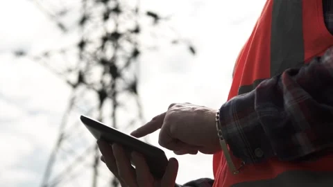 An electrical engineer inspects the power line and writes the data to the tablet Stock Footage 240458985