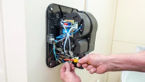 Electrical engineer installing an eco-friendly hand dryer in a washroom Stock Photos