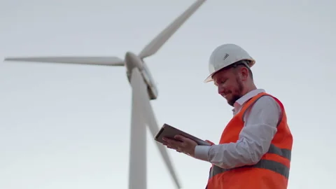 An electrical engineer looks at a modern digital tablet and raises his hand with Stock Footage 143684227