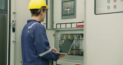 Electrical engineer performs a system diagnostic check with a laptop Stock Footage 345600168