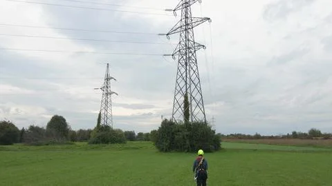 Electrical engineer servicing electricity pylons. Stock Photos