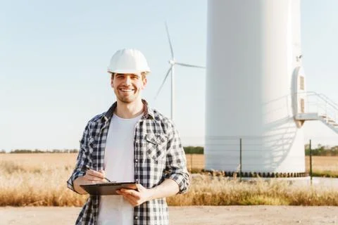 An electrical engineer standing on a field with windmills Stock Photos