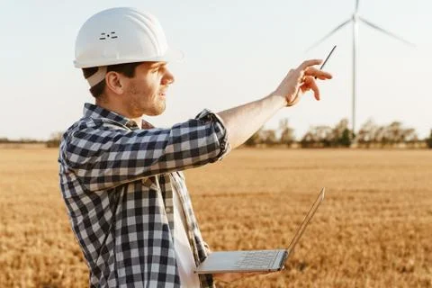 An electrical engineer standing on a field with windmills Stock Photos