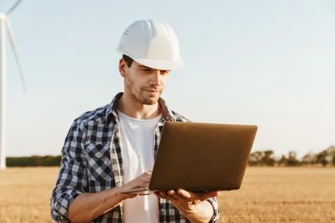 An electrical engineer standing on a field with windmills Stock Photos