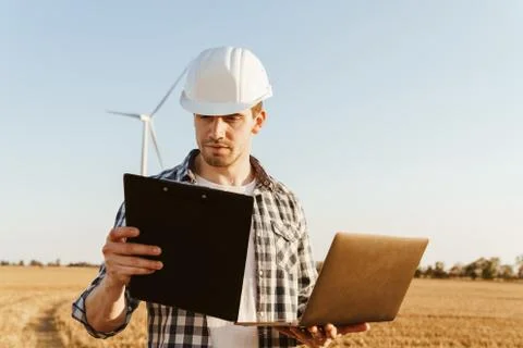 An electrical engineer standing on a field with windmills Stock Photos