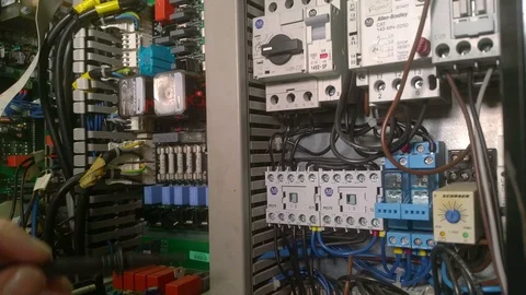 Electrical engineer testing contactors in a control panel Stock Footage 117004323