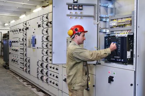 Electrical engineer uses equipment of the switchboard. Stock Photos
