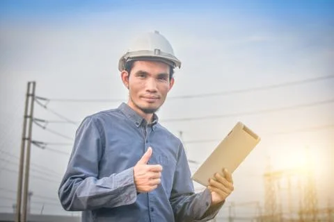 Electrical engineer uses a tablet to inspect Power plant network For power ge Stock Photos