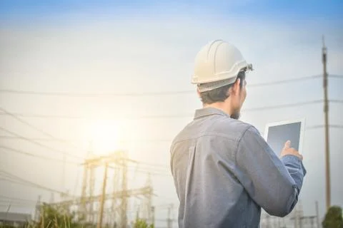 Electrical engineer uses a tablet to inspect Power plant network For power ge Foto stock