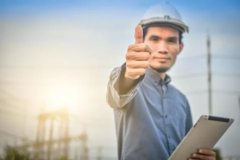 Electrical engineer uses a tablet to inspect Power plant network For power ge Foto stock