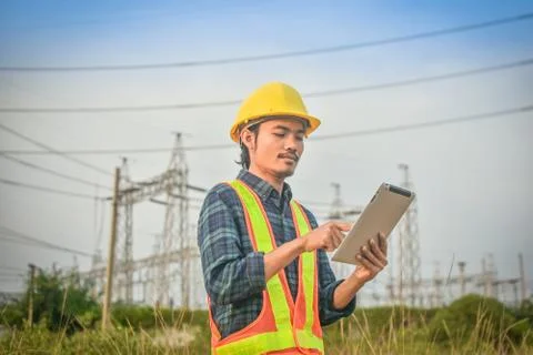Electrical engineer uses a tablet to inspect Power plant network For power ge Foto stock