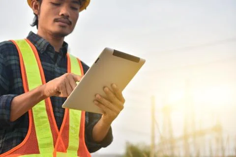 Electrical engineer uses a tablet to inspect Power plant network For power ge Foto stock