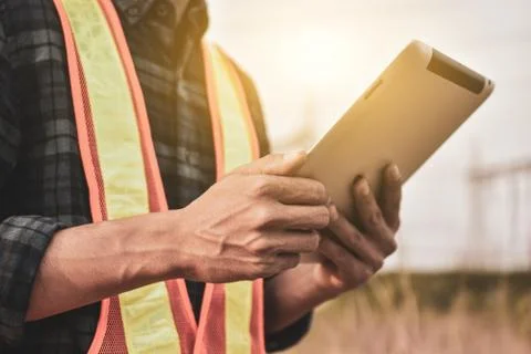 Electrical engineer uses a tablet to inspect Power plant network For power ge Stock Photos