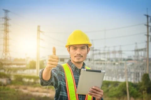 Electrical engineer uses a tablet to inspect Power plant network For power ge Foto stock