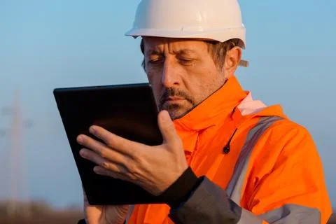 Electrical engineer using digital tablet computer out in the field close to.. Stock Photos