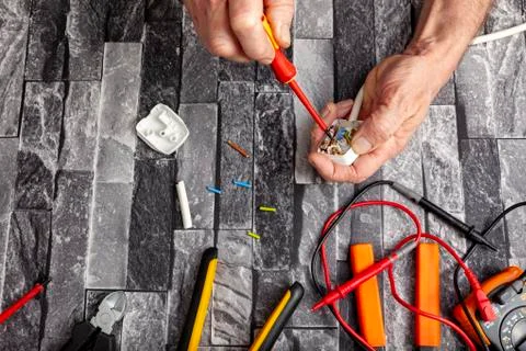 Electrical engineer using a screwdriver to fit a plug Foto stock