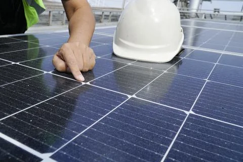 An electrical engineer wearing a white hat is checking. Solar panel cleanline Stock Photos