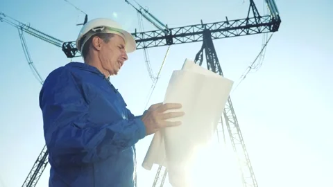 Electrical engineer worker in helmet power a working with documents, near tower Stock Footage 138258657