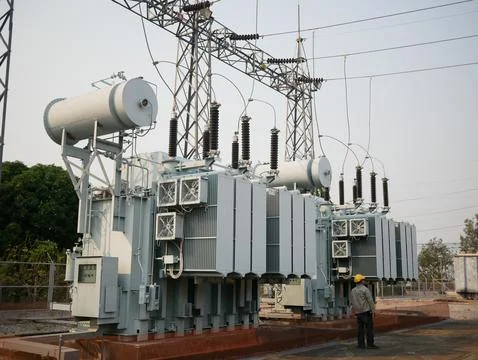 Electrical engineer worker inspecting large high voltage power transformer .. Stock Photos