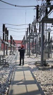 Electrical engineer worker wearing red safety helmet using thermal imaging .. Stock Photos