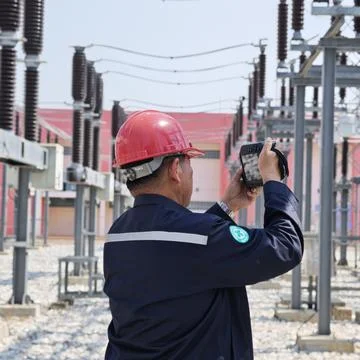 Electrical engineer worker wearing red safety helmet using thermal imaging .. Stock Photos