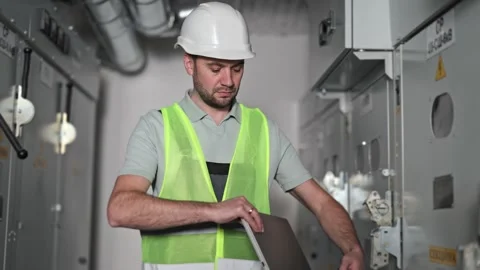 Electrical Engineer Working with Laptop Near Electrical Switchboard in Control Stock-Footage 297248195