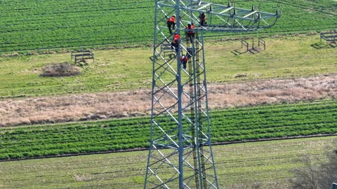 Electrical engineers working on electricity pylon Stockbeeldmateriaal 171143142